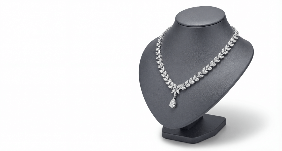 Prabangus deimantinis kaklo papuošalas su kriaušės formos pakabuku, eksponuojamas ant tamsaus papuošalų stovo