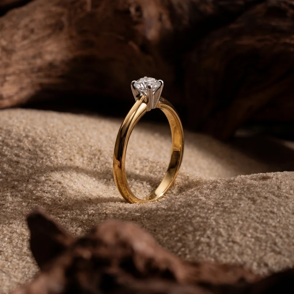 Sužadėtuvių žiedas Nr. S090 iš šono – geltono aukso žiedas su pakeltu briliantu