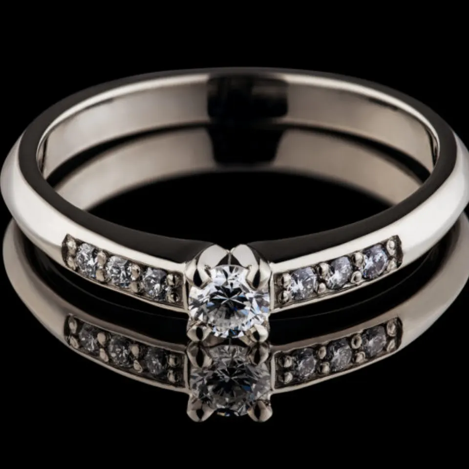 Sužadėtuvių žiedas Nr. S159 – balto aukso žiedas su centriniu deimantu ir šoniniais deimantais