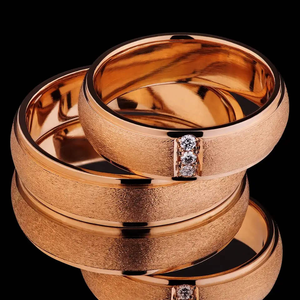 Vestuviniai žiedai Nr. V152 – 585 prabos raudono aukso vestuviniai žiedai su matiniu paviršiumi ir poliruotais kraštais, moteriškas žiedas su 3 briliantais (0,015 ct), bendras svoris 13 g